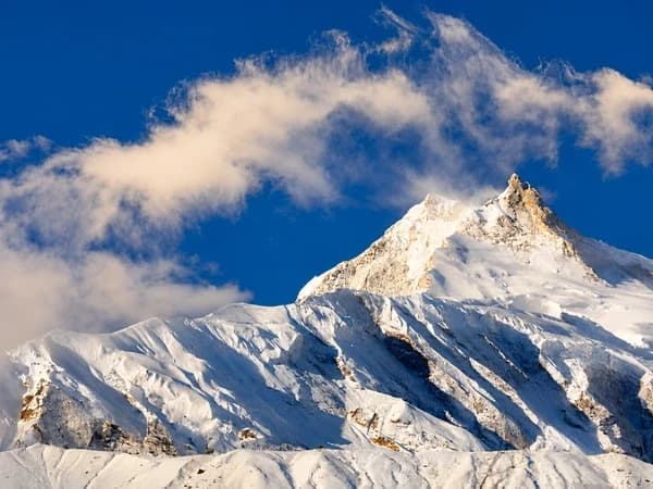 Snow-covered Manaslu Mountain peak and Himalayan clouds representing the best time for Manaslu Circuit Trek in Nepal, Thrill Himalaya Treks